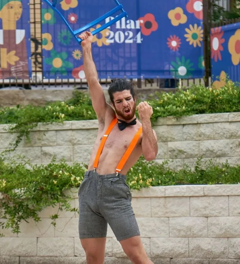 Hugo Grimalt Arnal bailando al aire libre con una silla en alto